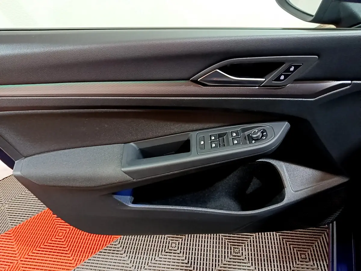 Vue rapprochée de la porte côté gauche de la Volkswagen Golf 1.0 TSI Active 2022 avec commandes de vitres et verrouillage.