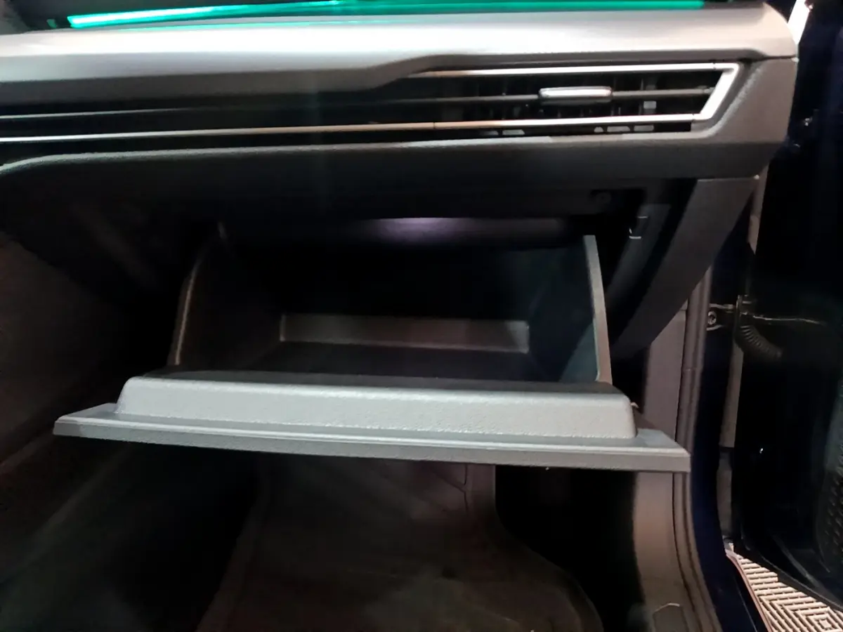 Gant de rangement ouvert côté passager dans l'habitacle d'une Volkswagen Golf bleu 2022.