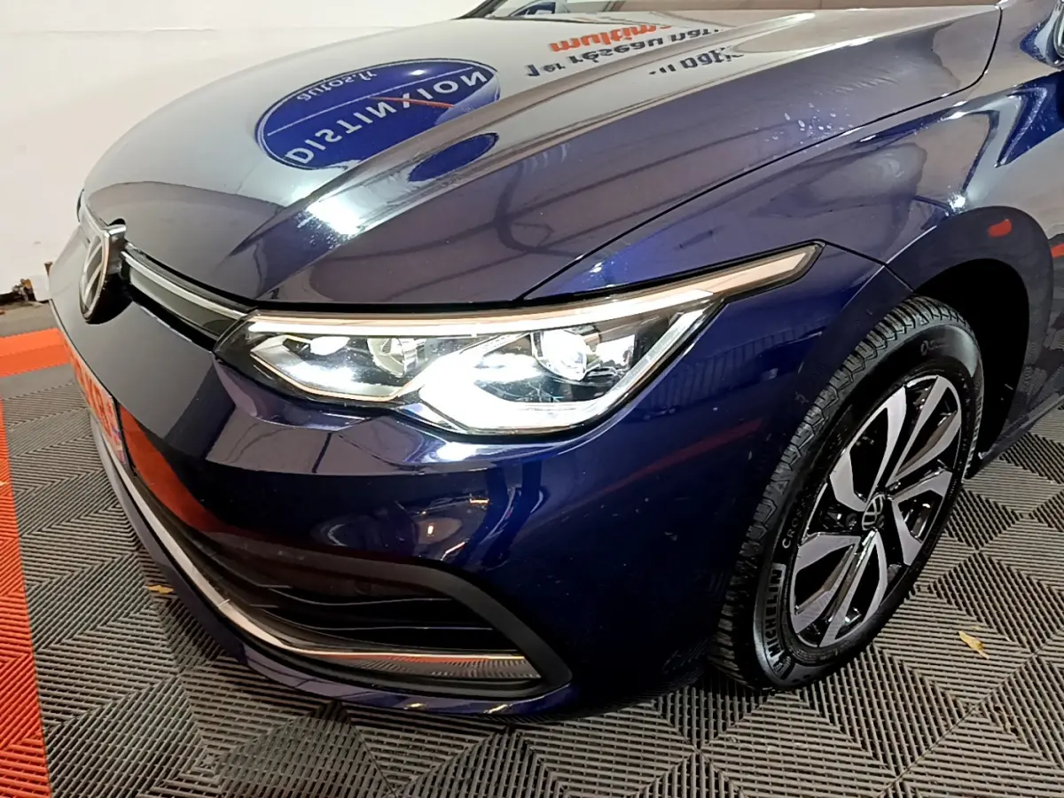 Vue 3/4 avant droit d'une Volkswagen Golf 1.0 TSI bleu avec phares LED et jantes alliage distinctives.