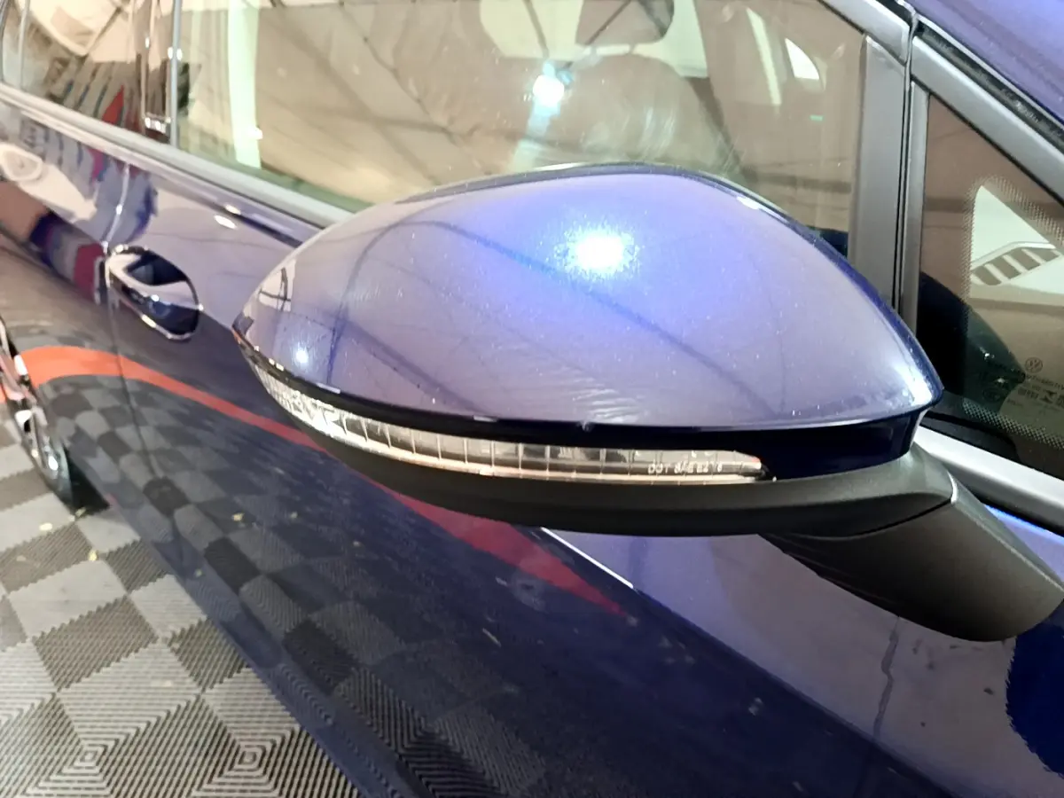 Rétroviseur côté gauche bleu brillant d'une Volkswagen Golf 1.0 TSI 2022 avec clignotant intégré.