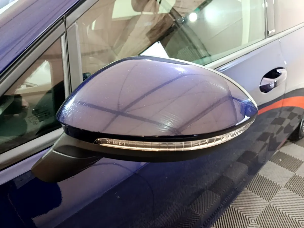 Rétroviseur côté gauche bleu de la Volkswagen Golf 1.0 TSI 2022 avec clignotant intégré, vue rapprochée.