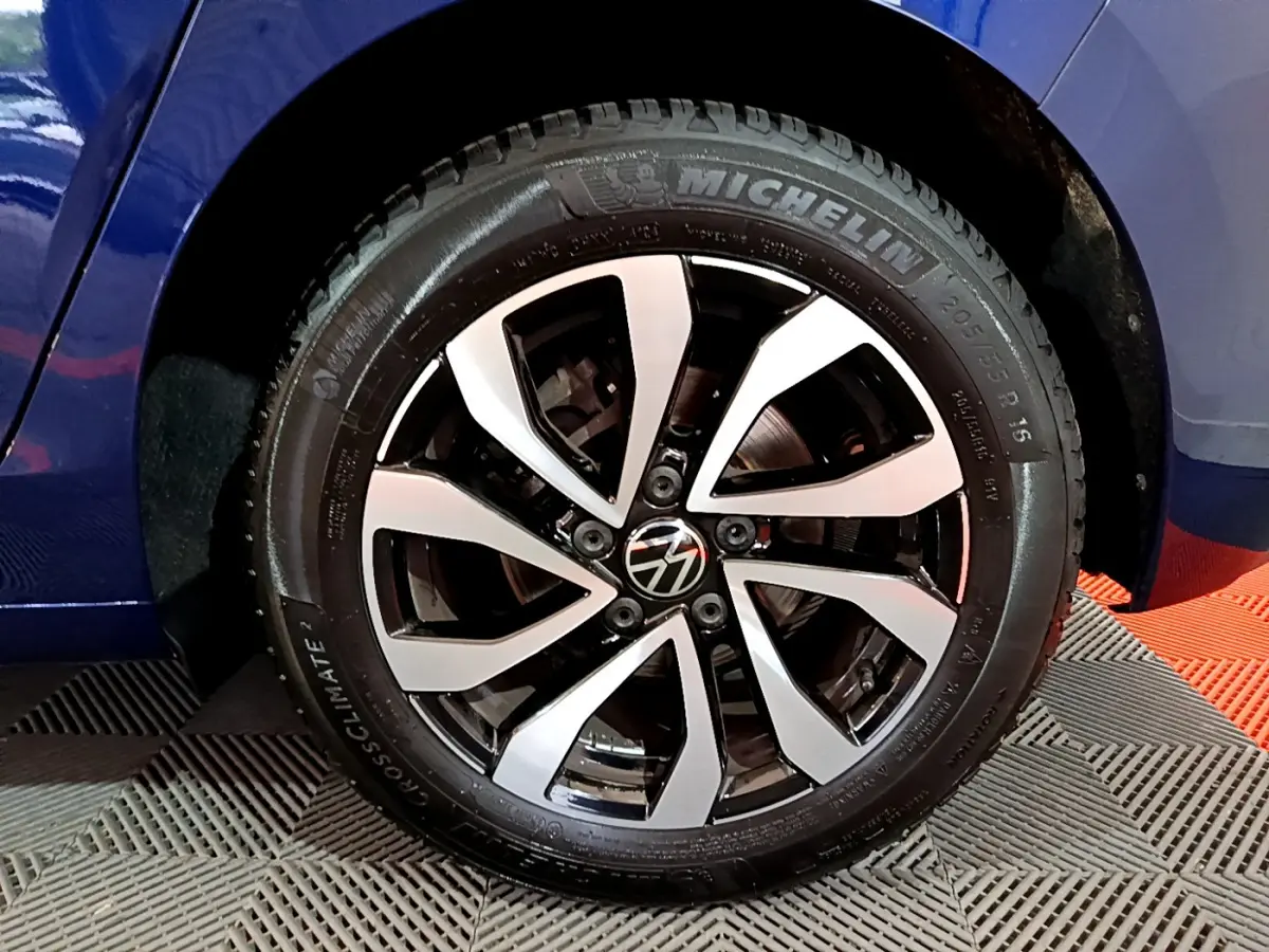 Gros plan sur la roue avant gauche de la Volkswagen Golf bleu, avec jante alliage bicolore et pneu Michelin.