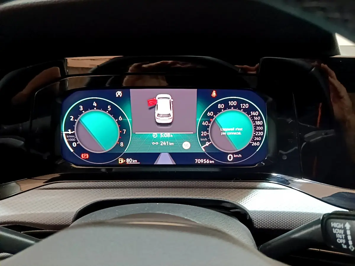 Tableau de bord numérique de Volkswagen Golf bleu, affichage multifonctions avec compteur vitesse et régime moteur.