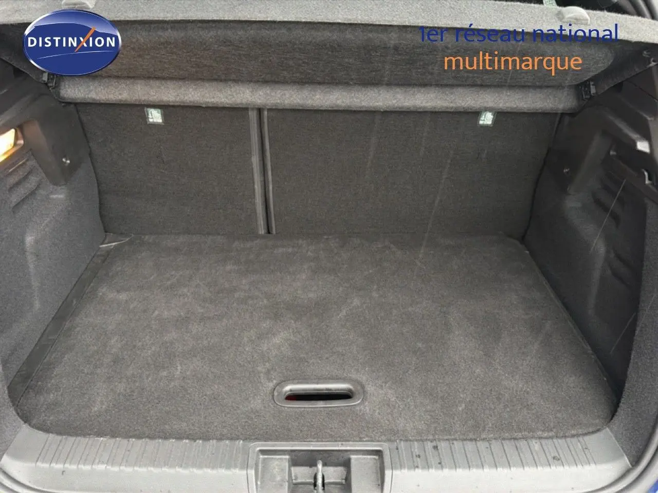 Coffre ouvert vu de face d'un Renault Captur 2025, intérieur noir avec tapis de sol en tissu.