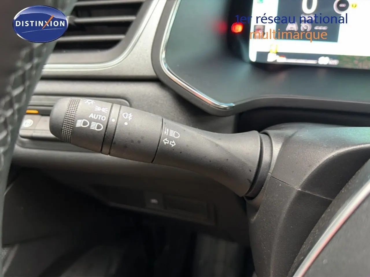 Gros plan sur la commande des feux à gauche du volant du Renault Captur bleu Iron Metal 2025, intérieur noir.