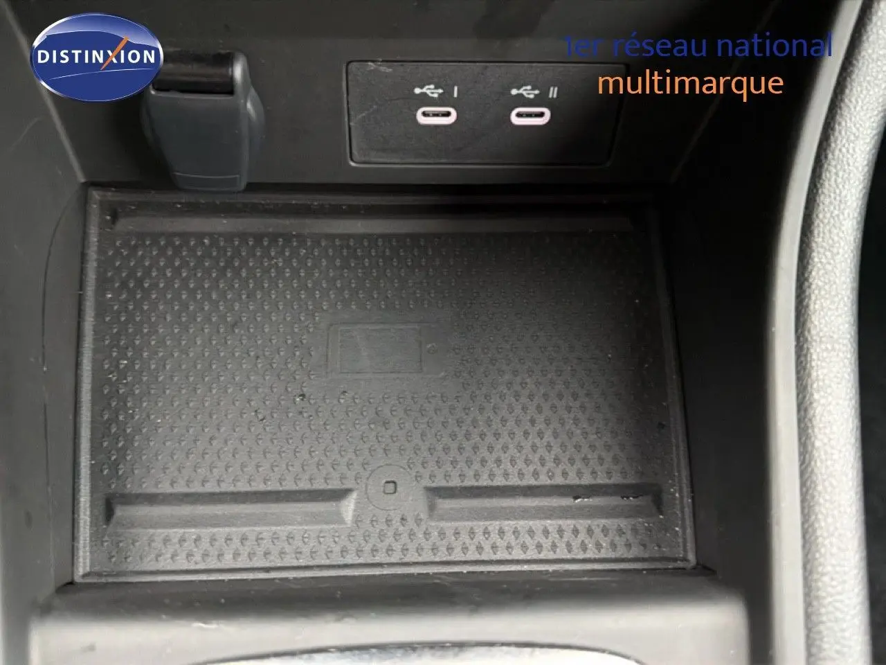Gros plan intérieur sur la console centrale du Renault Captur 2025, montrant les ports USB et le tapis antidérapant noir.