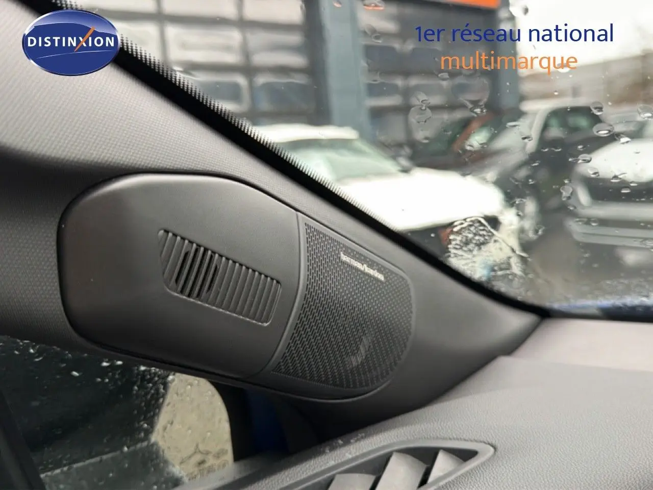 Détail de l'enceinte Harman Kardon côté gauche dans l'habitacle du Renault Captur bleu Iron Metal 2025.