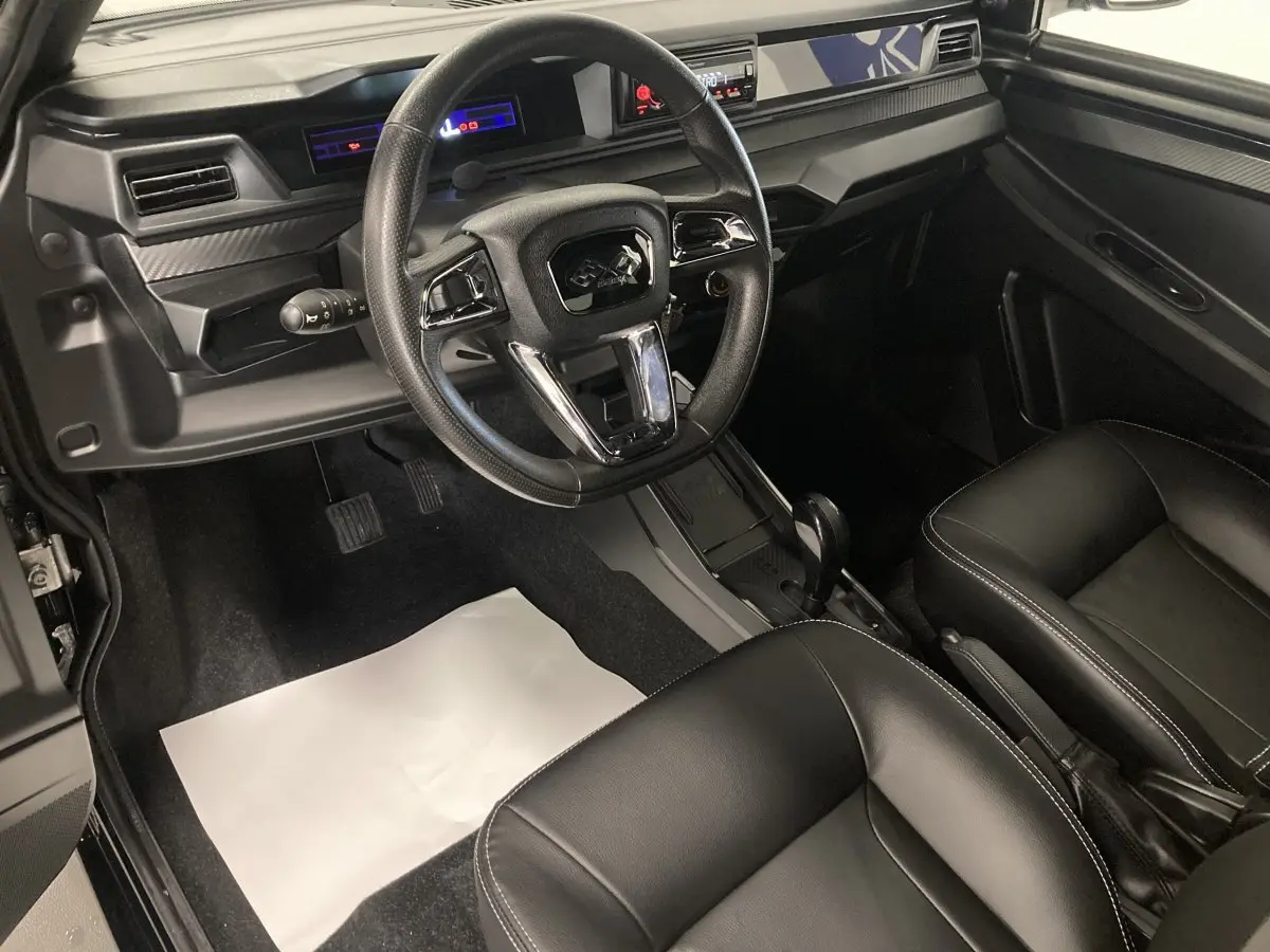 Vue intérieure côté conducteur de la LIGIER JS50 0.5 REVO D+ SELECT 2026, sièges confort noirs et tableau de bord moderne.