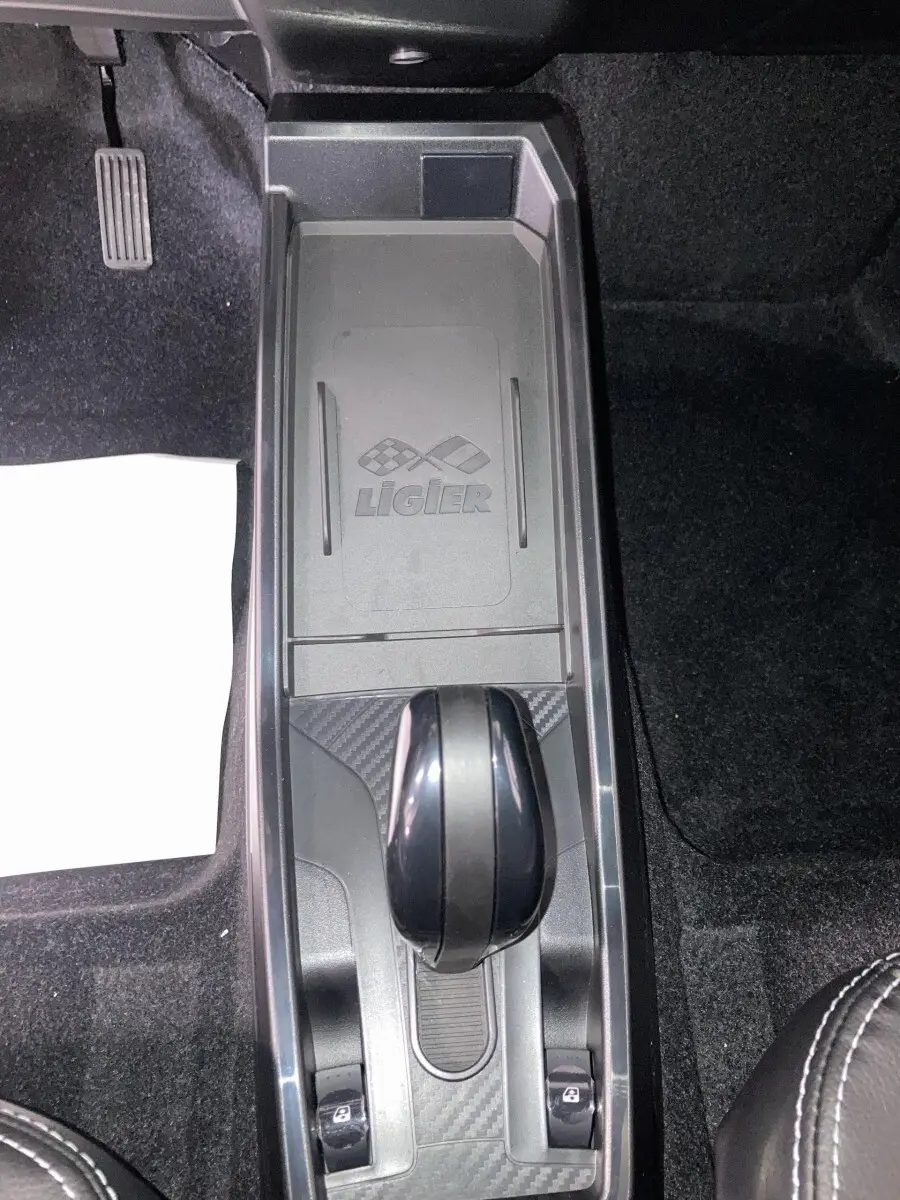 Vue plongeante sur la console centrale noire du Ligier JS50 0.5 REVO D+ avec levier de boîte auto et logo gravé.