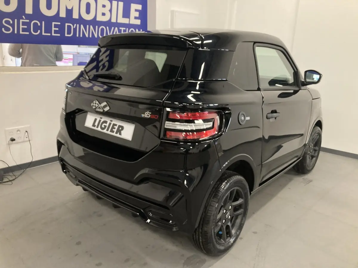 Vue 3/4 arrière droite d'une Ligier JS50 noire 2026 avec jantes alu noires et feux LED distinctifs.