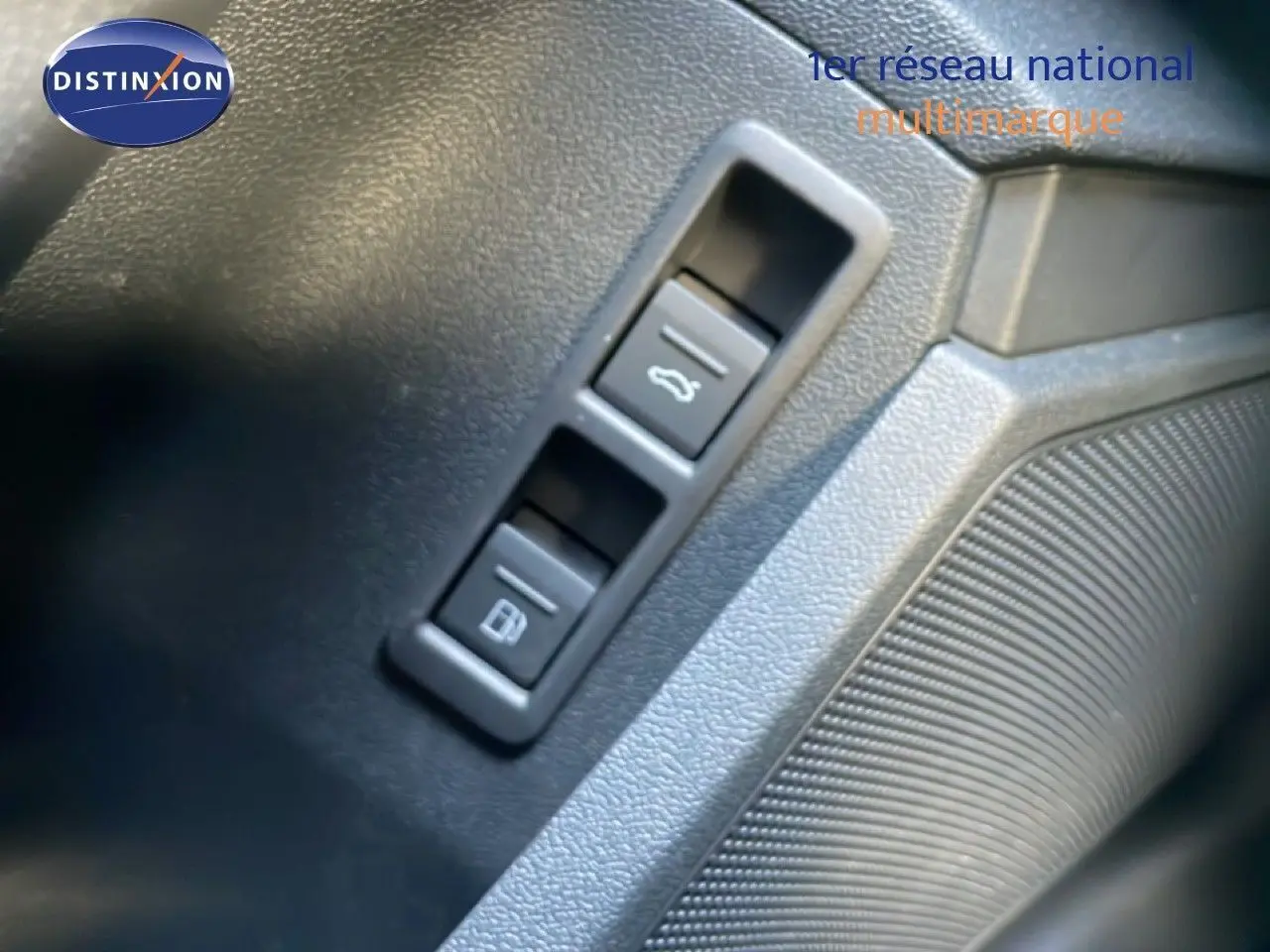 Gros plan sur les boutons d'ouverture du coffre et de la trappe à carburant dans l'habitacle d'une Audi A3 Sportback noire.
