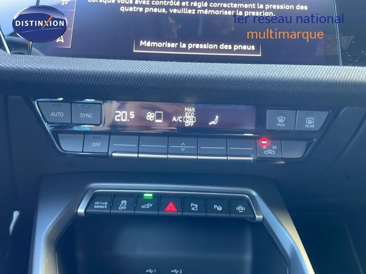 Vue rapprochée de la console centrale de l’Audi A3 Sportback noire 2025, montrant les commandes climatisation et fonctions hybrides.