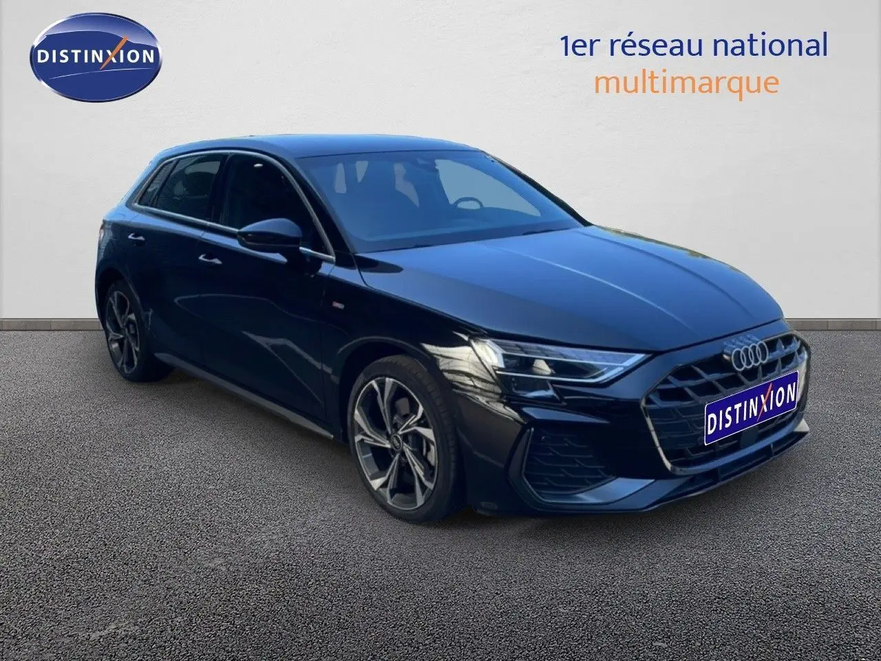 Audi A3 Sportback noire vue en 3/4 avant droit, mettant en valeur sa calandre large et ses jantes alliage distinctives.