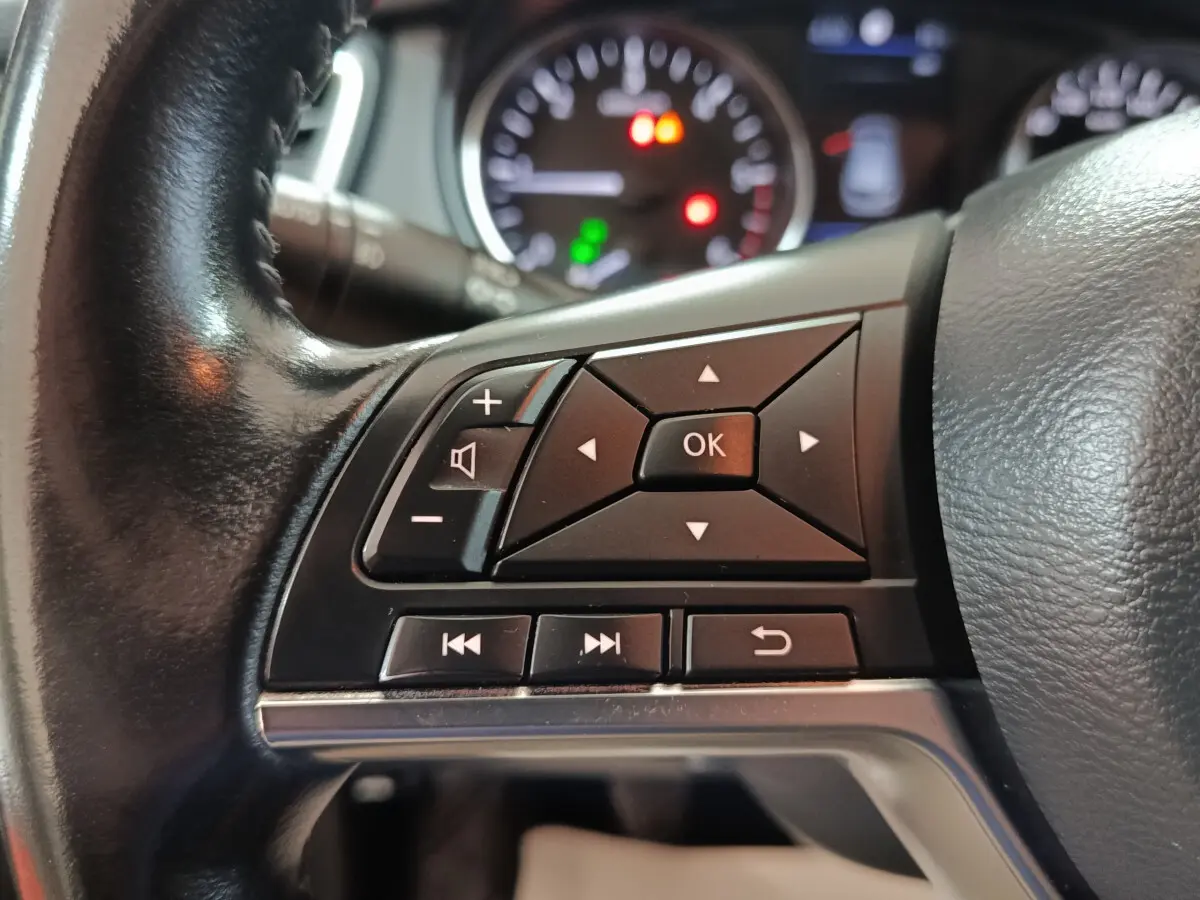 Gros plan sur les commandes multifonctions noires du volant cuir du Nissan Qashqai 1.5 DCI 115 Business Edition 2019.