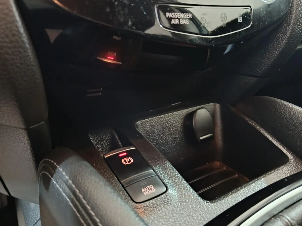 Gros plan sur la console centrale du Nissan Qashqai 2019 montrant le frein à main électrique et l'auto hold.