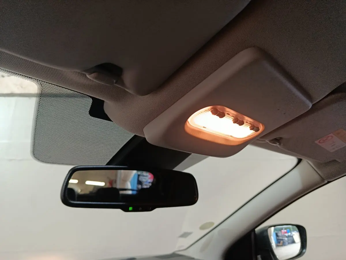 Plafonnier allumé et rétroviseur intérieur noir dans l'habitacle clair d'un Nissan Qashqai gris clair 2019.