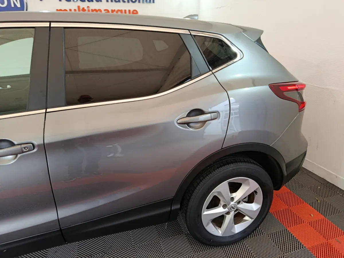 Vue côté droit arrière du Nissan Qashqai gris clair 2019 avec jante alliage et feux arrière LED distinctifs.