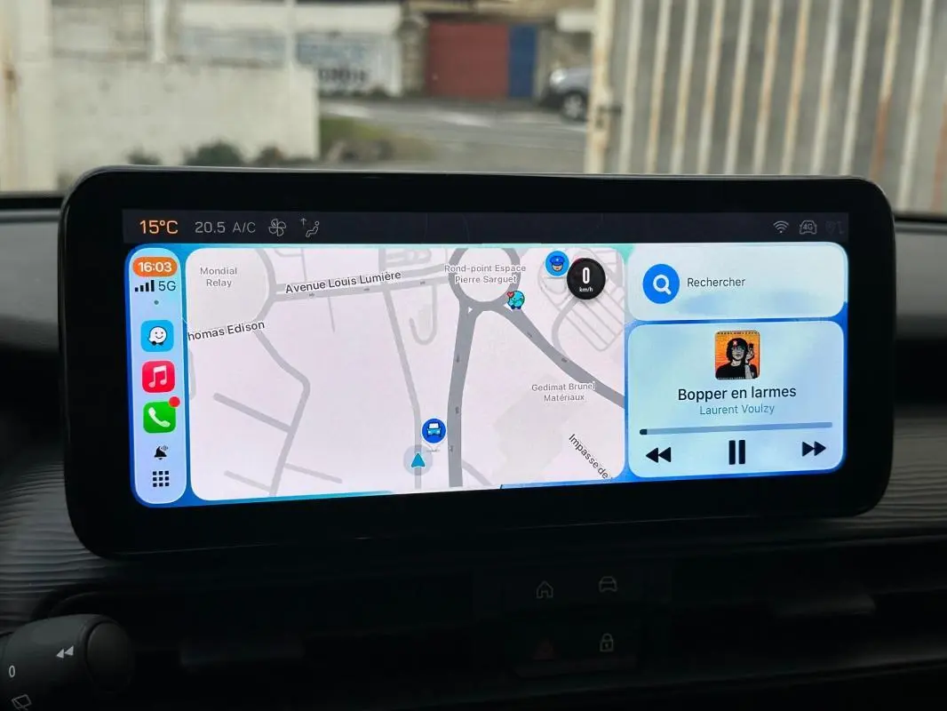 Écran tactile central du Jeep Avenger 2024 affichant la navigation et la musique, vue intérieure frontale.