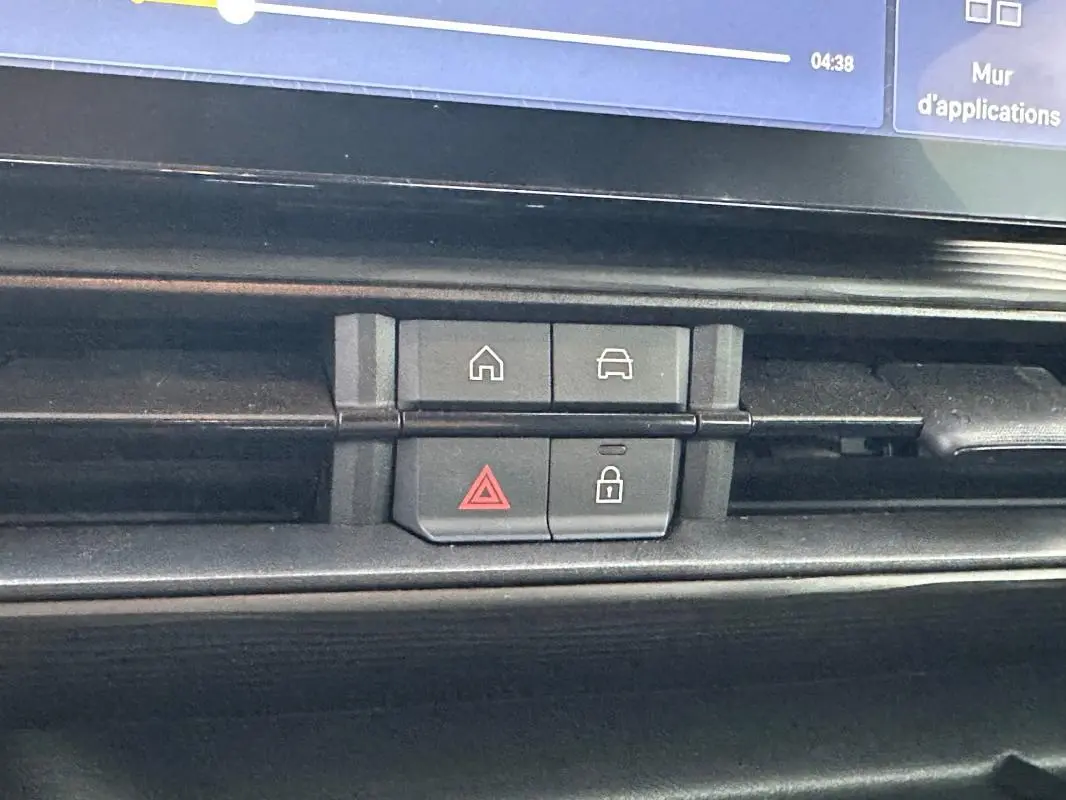 Détail du tableau de bord noir de la Jeep Avenger 2024 montrant les boutons de verrouillage et d'alerte.