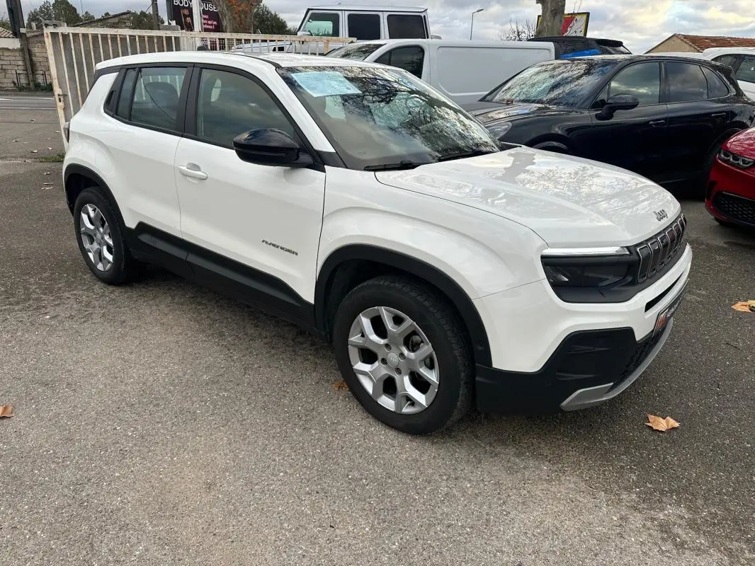 Vue 3/4 avant droite d'un Jeep Avenger blanc avec jantes alliage 17 pouces et rétroviseurs noirs.