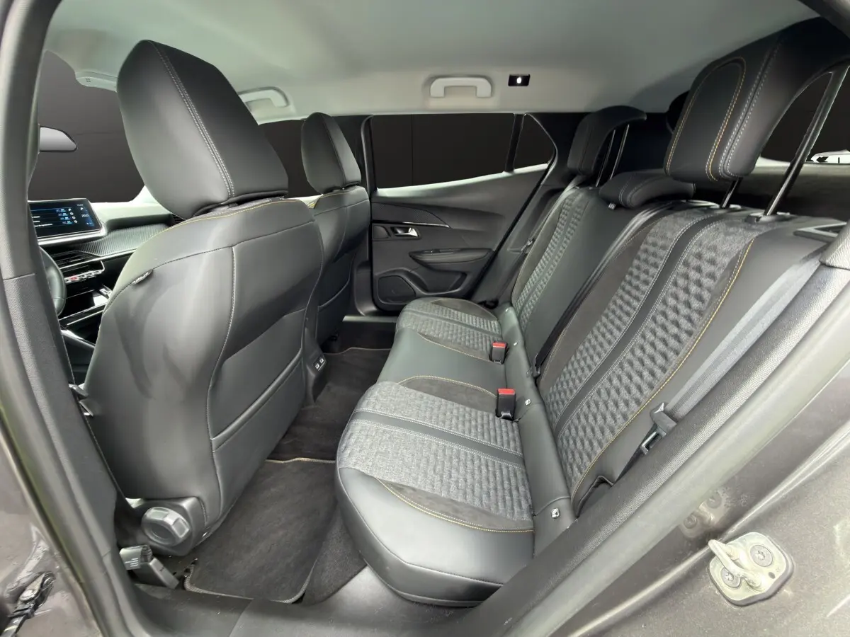 Vue intérieure arrière côté droit du Peugeot 2008 gris foncé, sièges mixtes cuir et tissu avec surpiqûres jaunes.