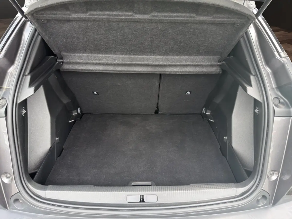 Coffre ouvert vu de l'arrière d'un Peugeot 2008 gris foncé, montrant un espace de chargement propre et spacieux.