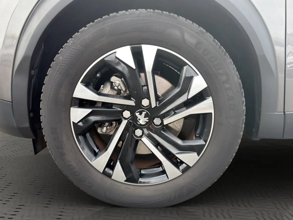 Gros plan sur la roue avant droite du Peugeot 2008 gris foncé avec jante alliage noire et argentée.