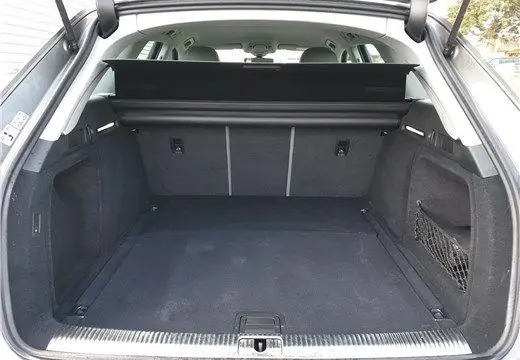 Coffre ouvert en vue arrière d'une Audi A4 Avant Business gris Terra, montrant un espace de chargement spacieux et propre.
