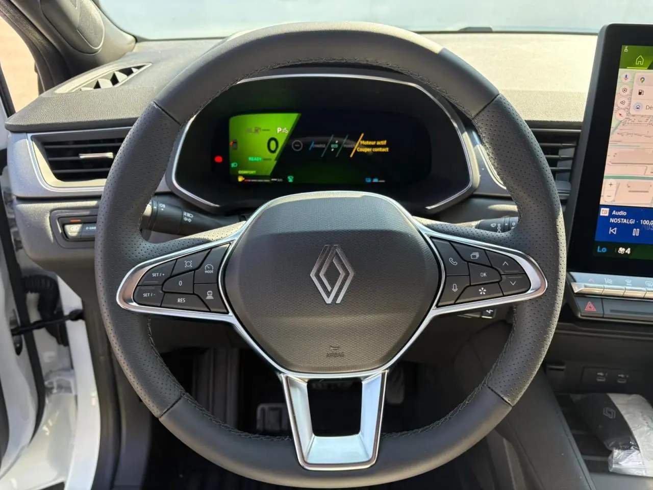 Vue centrée sur le volant noir du Renault Symbioz 2025 avec tableau de bord numérique et écran tactile latéral.