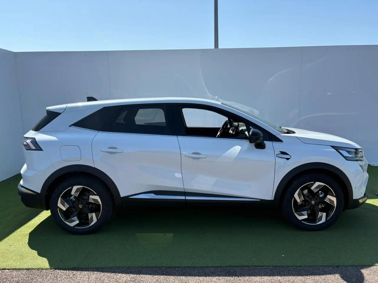 Profil latéral droit d'un Renault SYMBIOZ blanc nacré avec jantes 18 pouces au design moderne sur fond neutre.