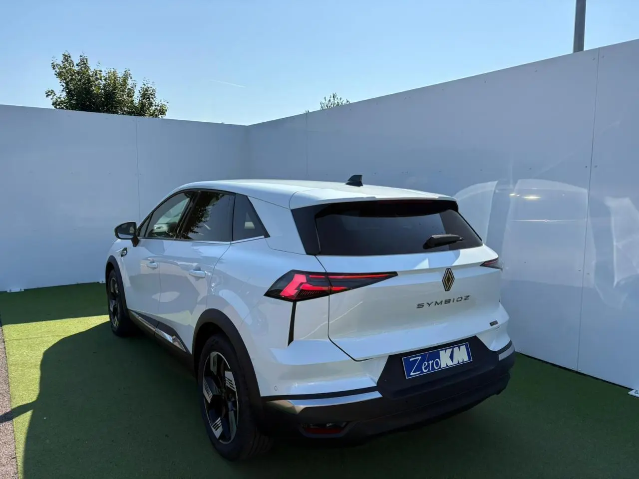 Vue 3/4 arrière droite d'un Renault Symbioz blanc nacré avec feux arrière LED et jantes 18 pouces Gravity.
