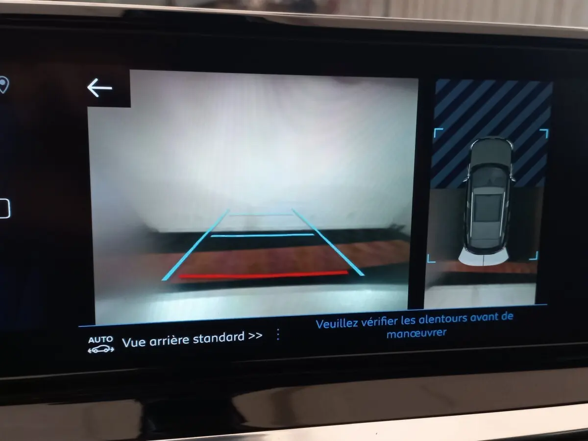 Écran tactile du système de navigation montrant la caméra de recul et l'aide au stationnement du Peugeot 2008 orange.