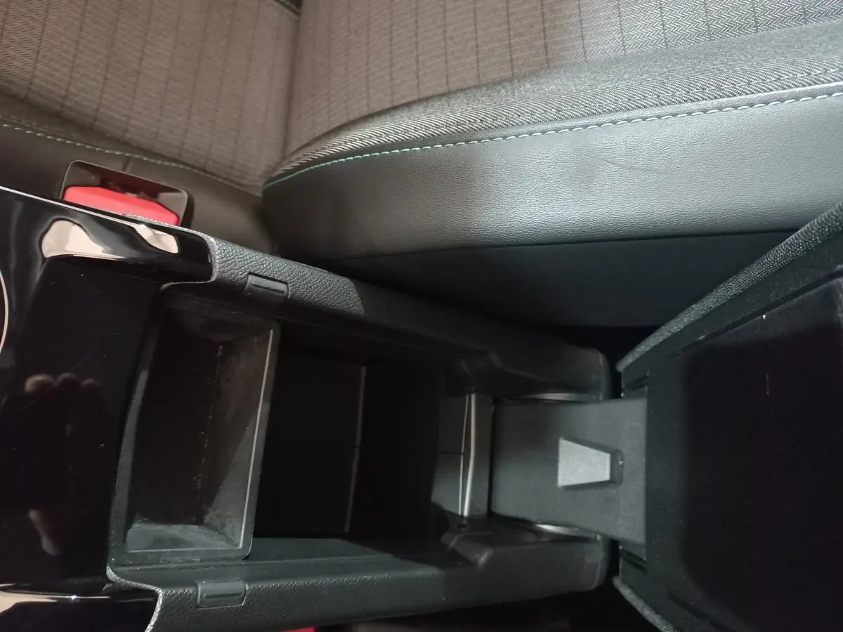 Vue rapprochée de la console centrale noire et du siège avant gris du Peugeot 2008 Orange 2021.