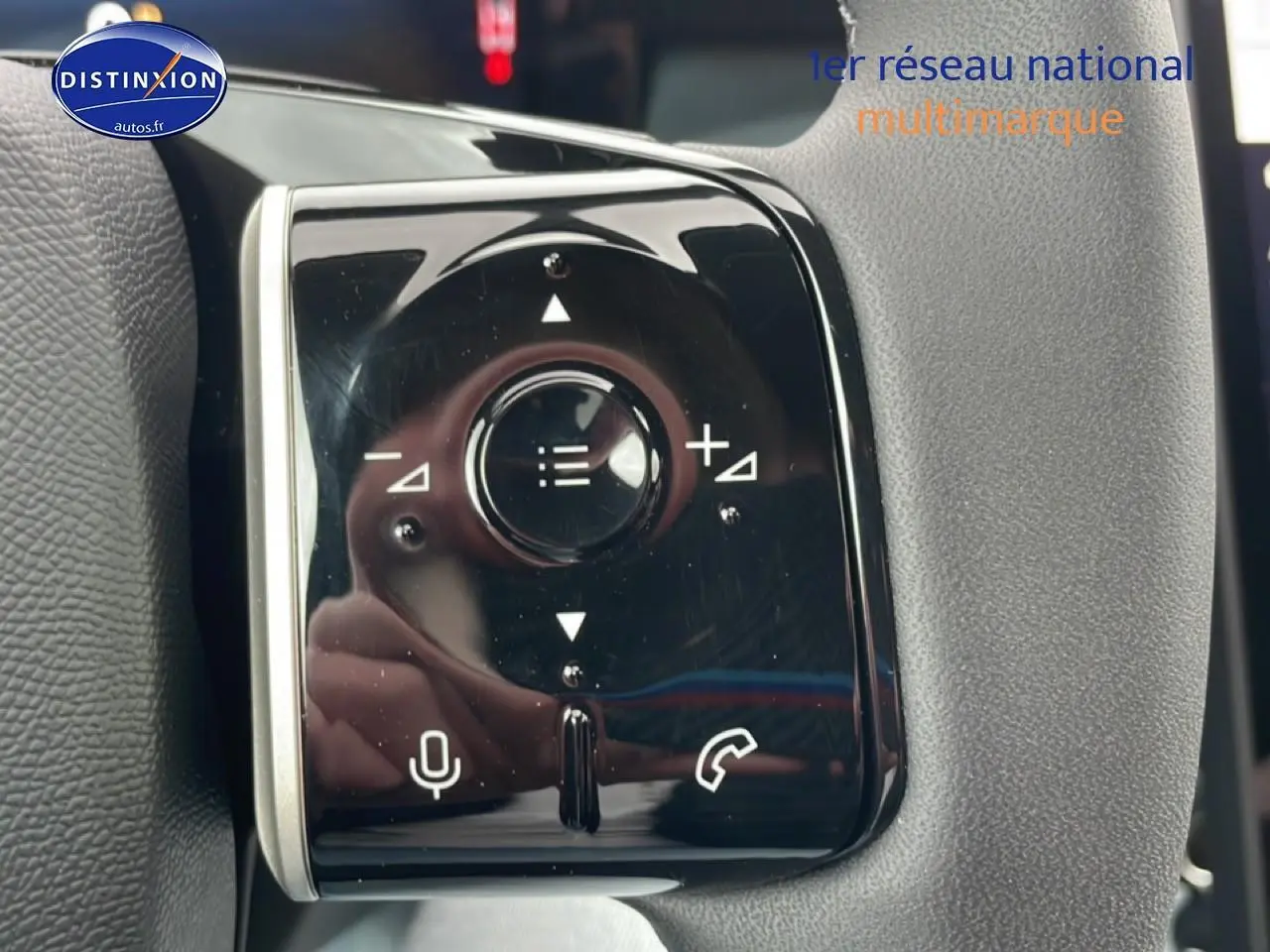 Gros plan sur les commandes multifonctions noires du volant du Citroën C5 Aircross gris platinium, version hybride 2026.