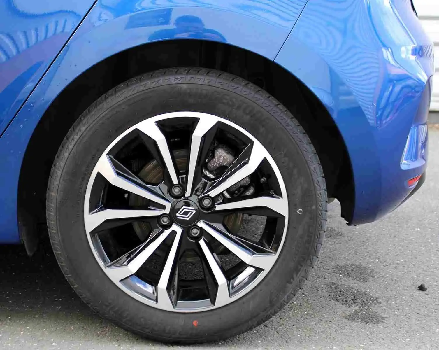 Gros plan sur la roue avant gauche de la Renault Clio bleu iron metal, mettant en valeur la jante alliage au design moderne.