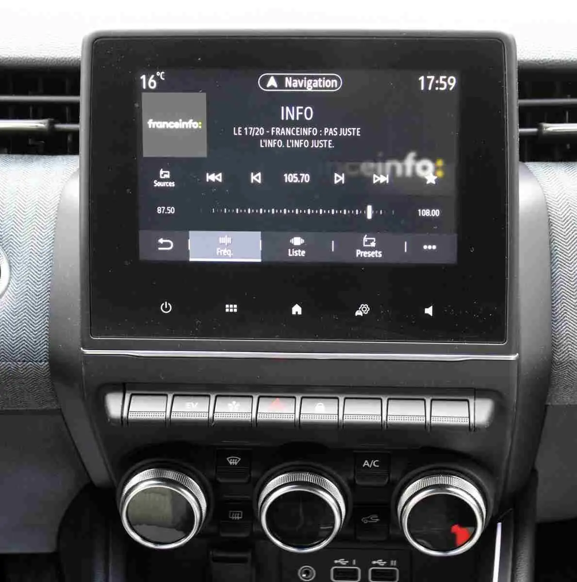Vue rapprochée de l'écran tactile central et des commandes de climatisation du Renault Clio 2025 en intérieur gris-noir.