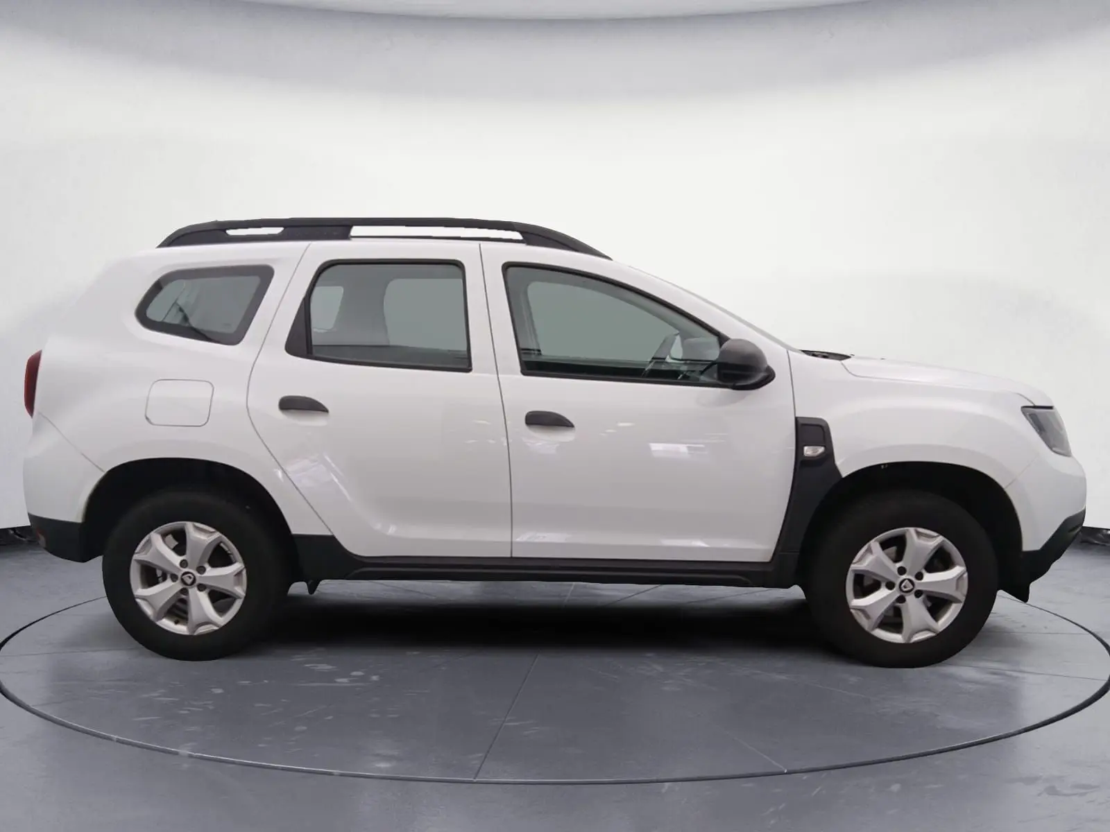 Profil côté gauche d'un Dacia Duster blanc 2021, version 4X2 ECO-G avec jantes alliage et barres de toit noires.
