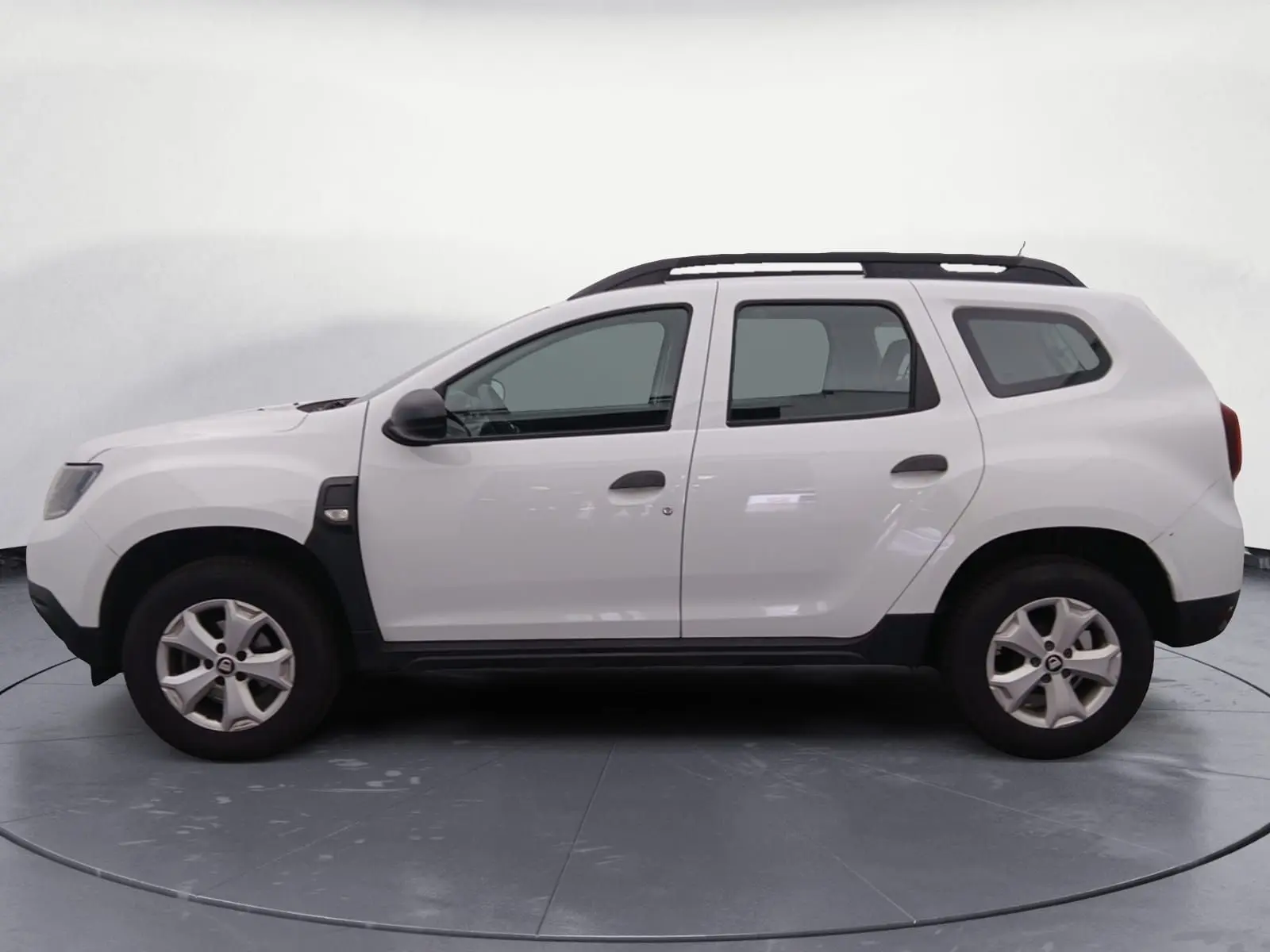 Vue latérale droite d'un Dacia Duster blanc 4x2 Eco-G 100 Essentiel avec barres de toit et jantes alliage.