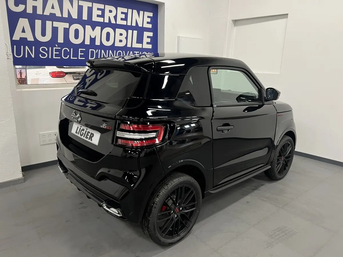 Vue 3/4 arrière droite d'une LIGIER JS50 noire mate avec jantes alu 16" noires et toit ouvrant coulissant.