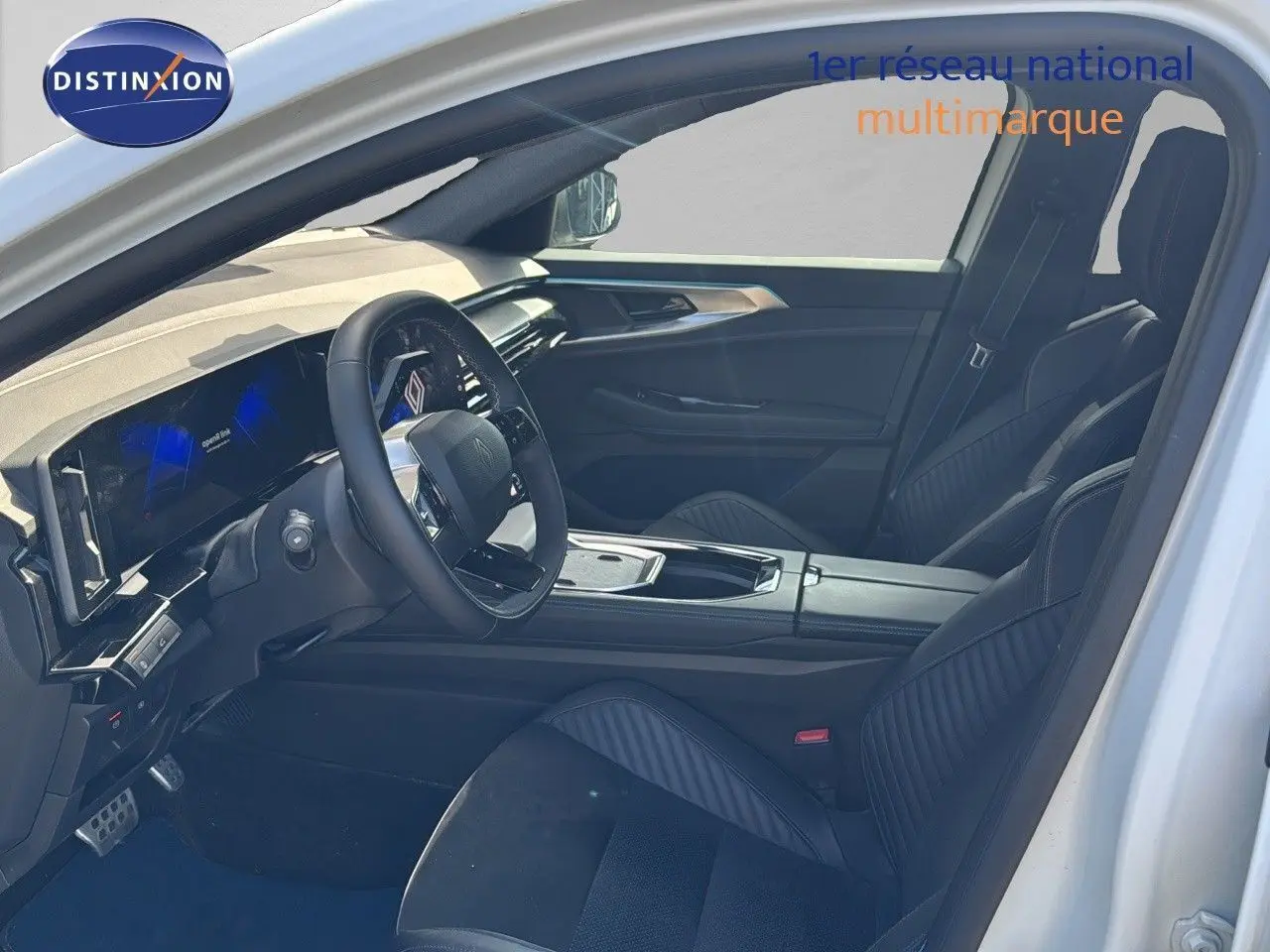 Vue intérieure côté conducteur du Renault Rafale blanc 2024, mettant en valeur le tableau de bord numérique et les sièges sport noirs.