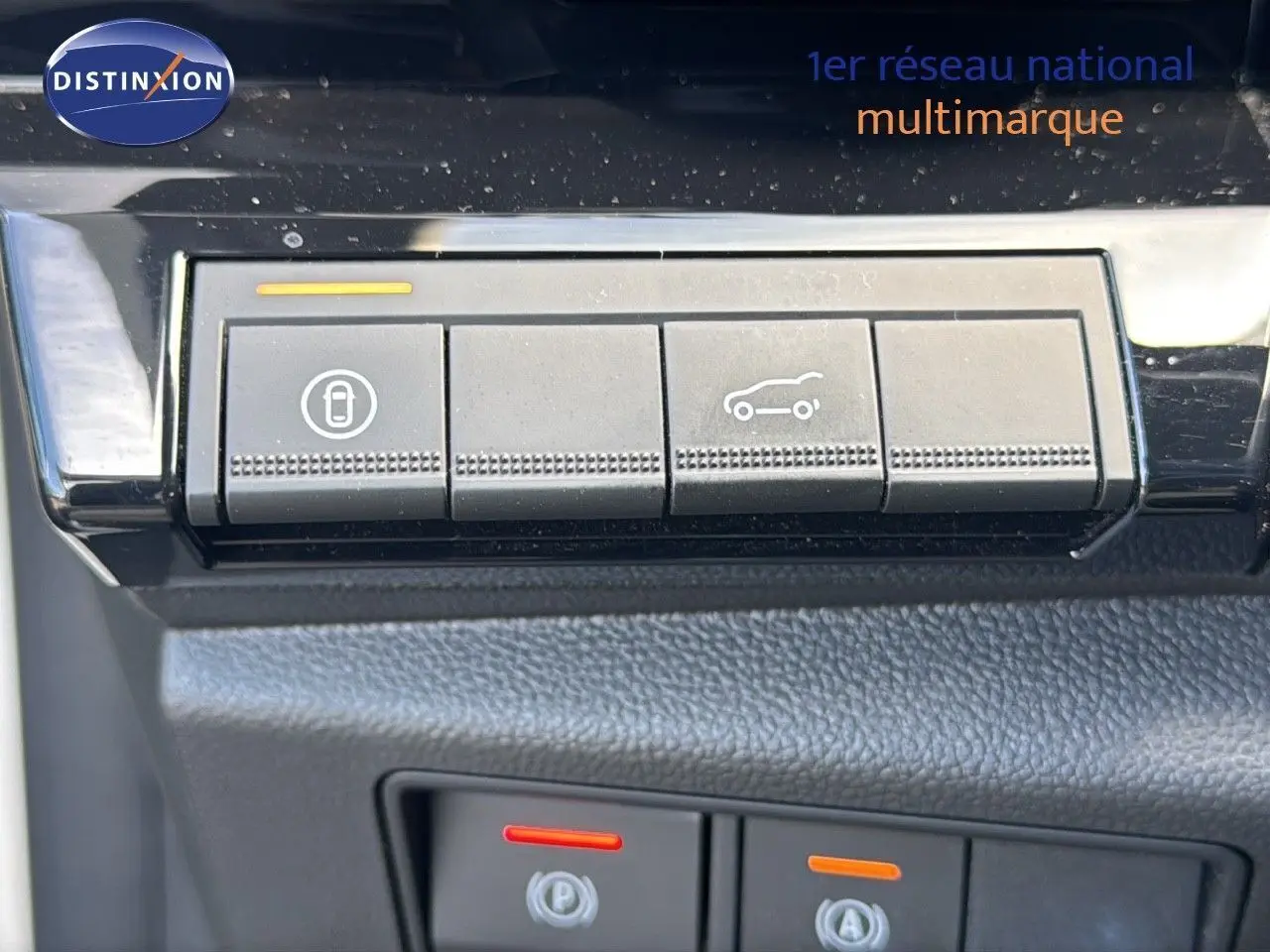 Gros plan sur les boutons de commande intérieurs du Renault Rafale blanc, avec icônes de verrouillage et ouverture du coffre.
