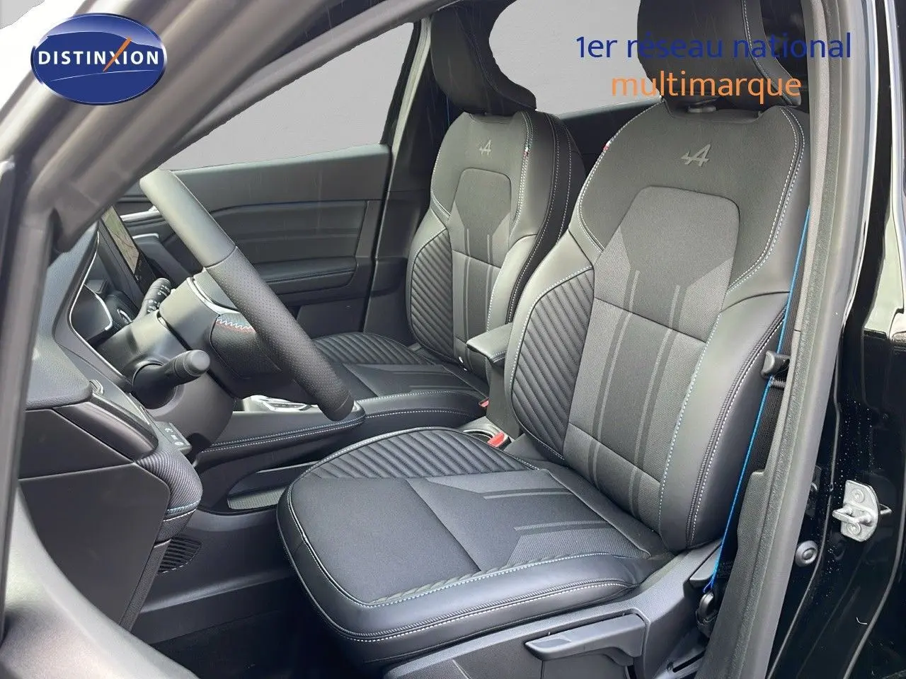 Vue intérieure côté conducteur du Renault Captur E-Tech hybride 2025, sièges noirs avec surpiqûres bleues et logo Alpine brodé.