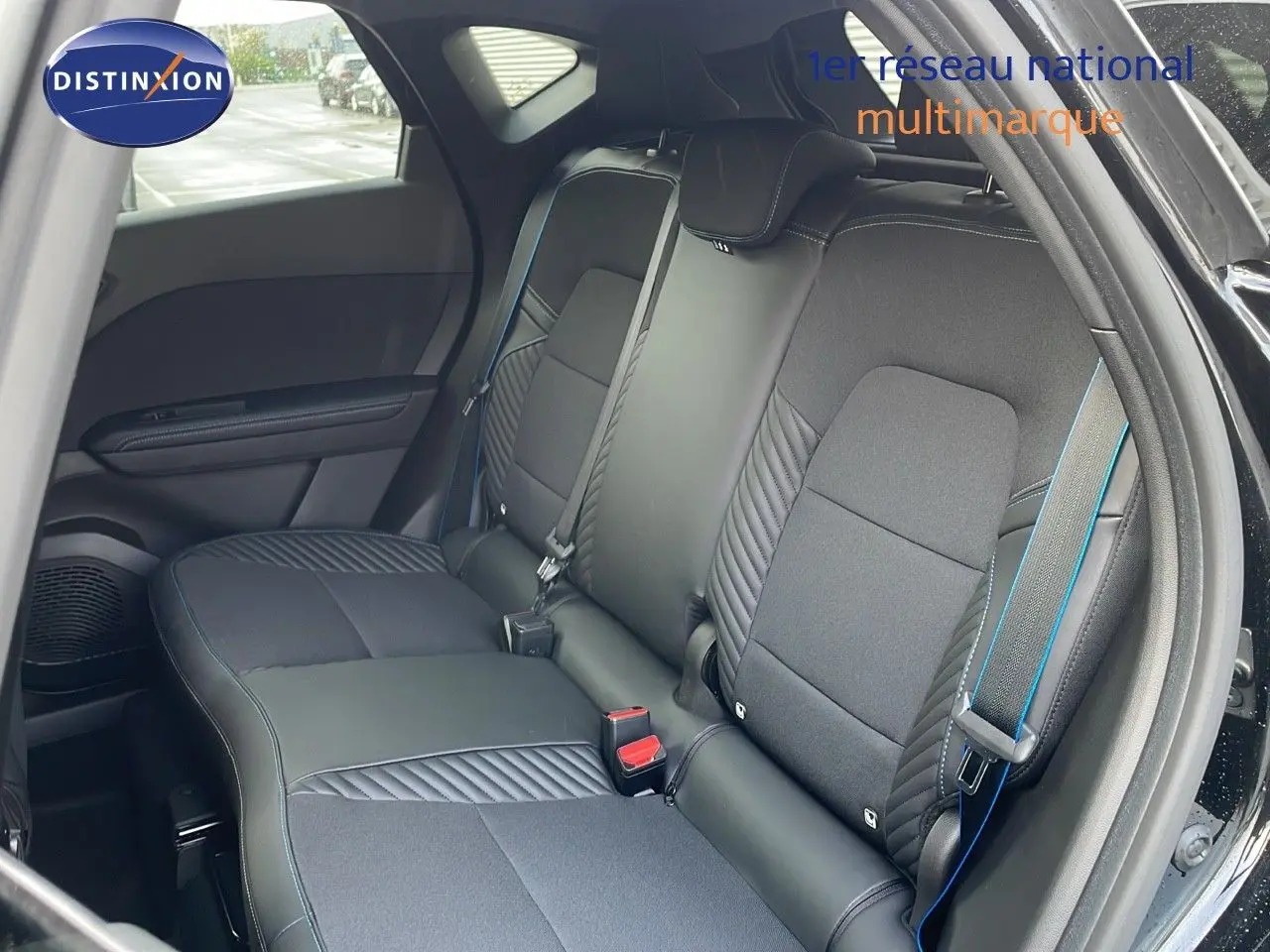 Vue intérieure sur les sièges arrière en tissu et cuir noir avec surpiqûres bleues du Renault Captur E-Tech 2025.