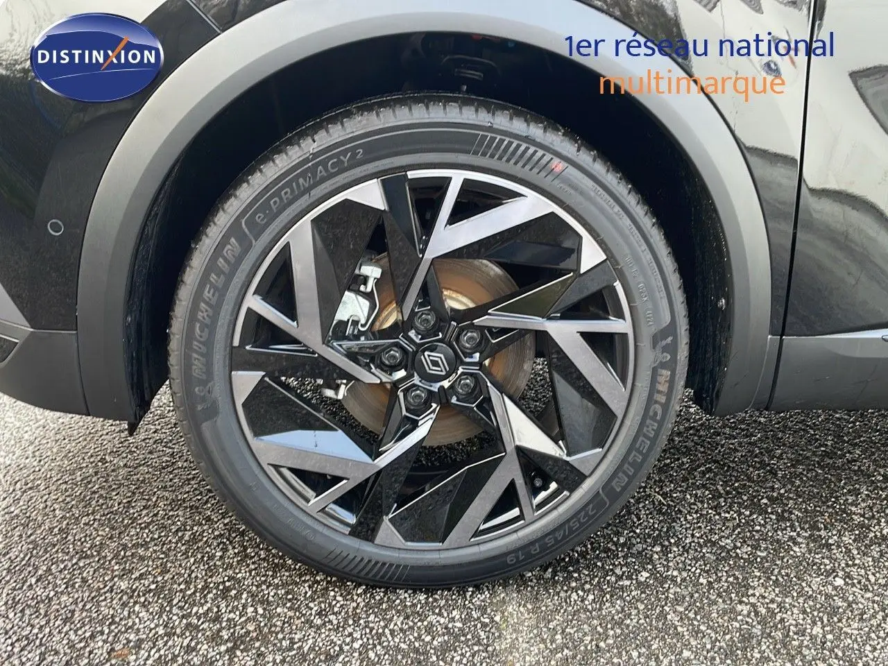 Gros plan sur la jante noire et grise au design géométrique du Renault Captur E-Tech hybride 2025 noir étoile.