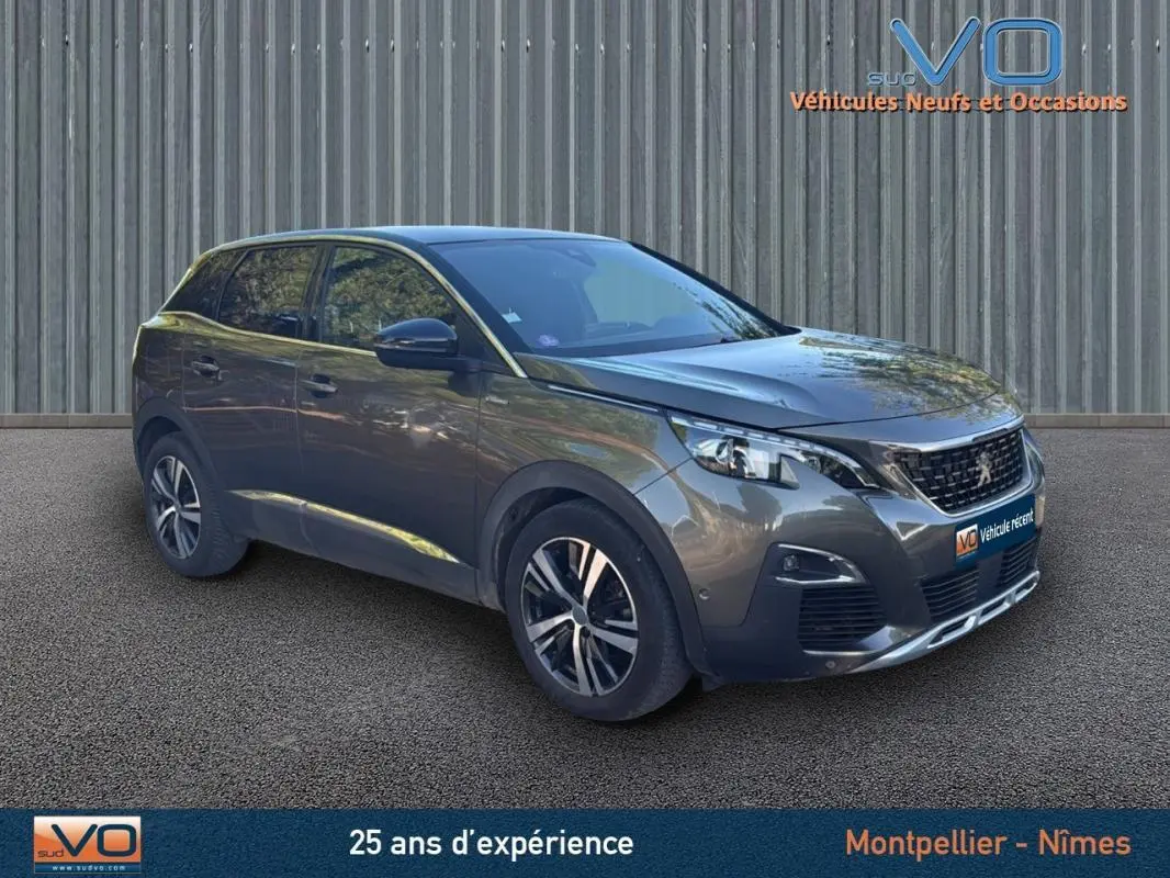 Peugeot 3008 gris foncé en vue 3/4 avant droit, avec jantes alliage 18 pouces et calandre noire distinctive.