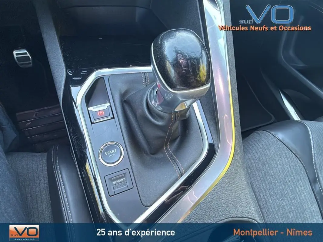 Gros plan sur la console centrale d’un Peugeot 3008 gris foncé 2018 avec levier de vitesse manuel et bouton start/stop.