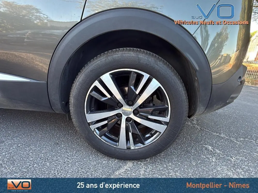 Gros plan sur la roue arrière droite du Peugeot 3008 gris foncé avec jante alliage 18 pouces design bicolore