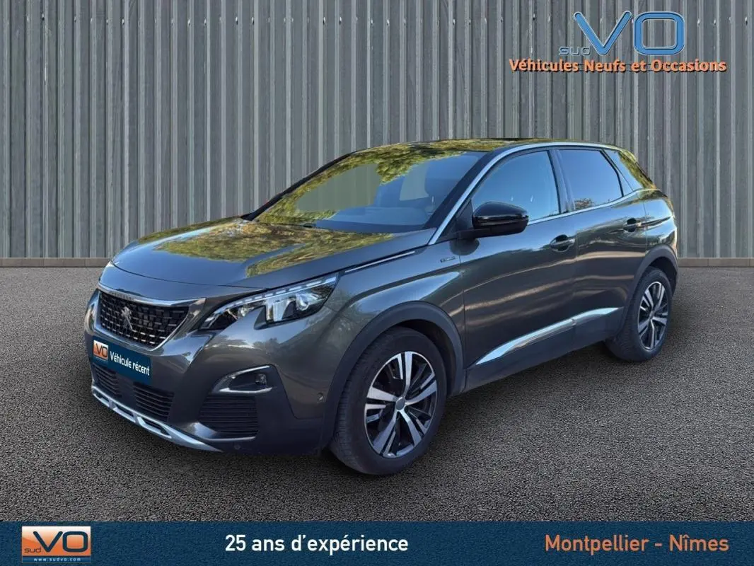 Peugeot 3008 gris foncé en 3/4 avant droit, avec jantes alliage 18 pouces et phares LED visibles.