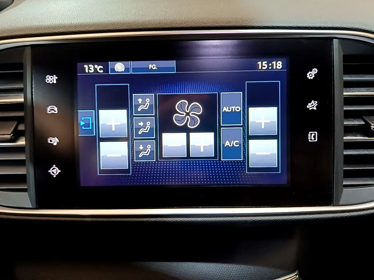 Écran tactile central affichant les commandes de climatisation de la Peugeot 308 gris foncé, vue de face.