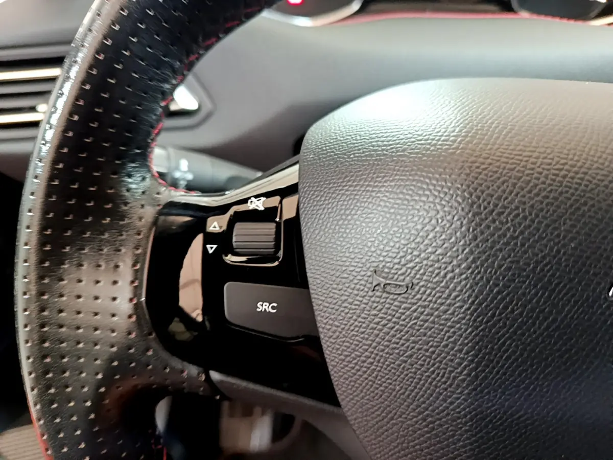 Gros plan sur le volant cuir perforé avec commandes intégrées du Peugeot 308 GT Line gris foncé de 2016.